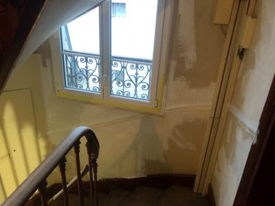 Cage d'escalier au bout du couloir après la première couche d'enduit